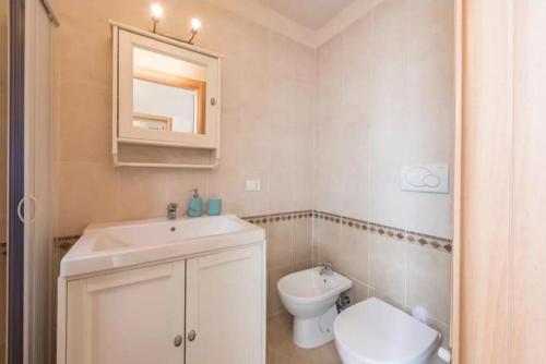 a white bathroom with a sink and a toilet at Domus Chiara in Monopoli