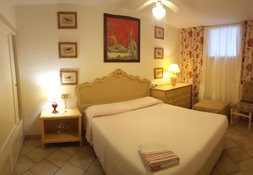 ゴルフォ・アランチにあるTaverna Derosasのベッドルーム1室(白いベッド1台、テーブル2台、ランプ2つ付)