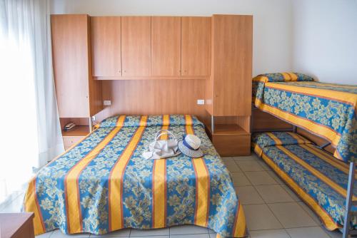 a bedroom with two beds with a hat on the bed at Pensione Villa Joli in Lido di Jesolo