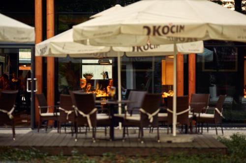a table with chairs and umbrellas in front of a restaurant at Bristol Art & Medical SPA in Busko-Zdrój