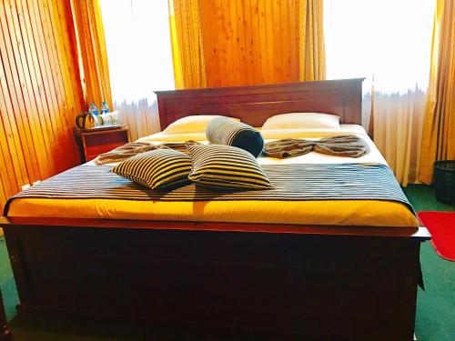 a bed with pillows on it with aedes at Single Tree Hotel in Nuwara Eliya