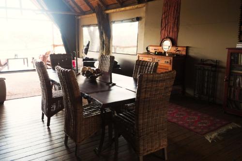 a dining room with a wooden table and chairs at South Okavango - Omogolo Hideaways in Rammu