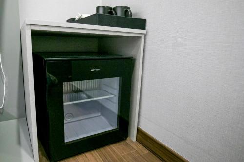 a black refrigerator with its door open in a room at Philstay Myeongdong Station in Seoul