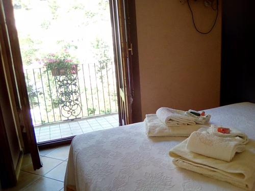 Habitación con cama con toallas y ventana en Bed and breakfast La Sentinella en Civita