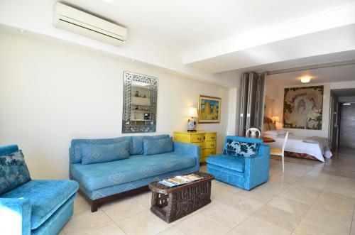 a living room with blue couches and a bedroom at 702 Canal Quays in Cape Town