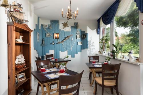Frühstückspension Landhaus Lange في بريرو: غرفة طعام بها طاولات وكراسي وجدار أزرق