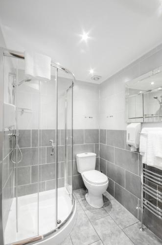 a bathroom with a toilet and a glass shower at Argyll Apartments in Glasgow