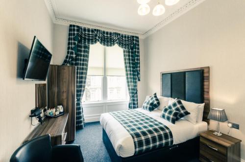a hotel room with a bed and a window at Argyll Apartments in Glasgow