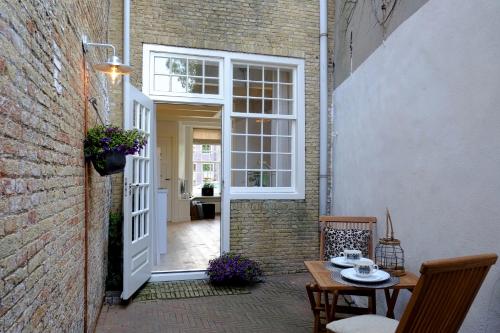an open door to a patio with a table and chairs at Huisje aan de gracht in Franeker