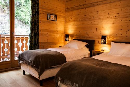 a bedroom with two beds in a log cabin at Chalet Tara in Morzine