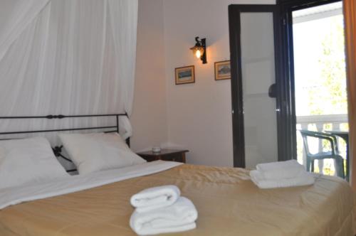 
a bed with white sheets and a white comforter at Byzance Hotel in Skala
