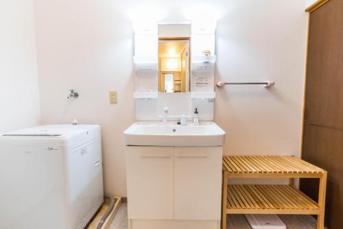 Bijou Suites Ferries Wheel View في أوساكا: حمام صغير مع حوض ومرآة
