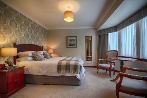 a bedroom with a bed and a desk and a chair at Strathburn Hotel Inverurie by Compass Hospitality in Inverurie