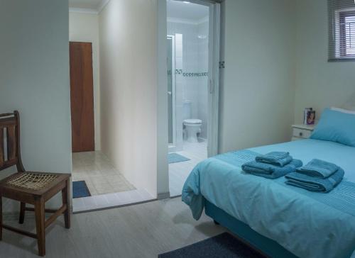 a bedroom with a bed and a bathroom with a shower at Lientjies Overnight in George