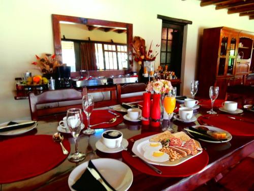 una mesa con comida y copas de vino. en African Footprints Lodge, en Midrand