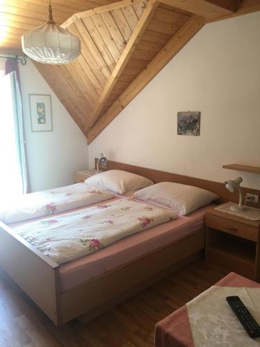 a bedroom with two beds in a room with wooden ceilings at Weingut Zundlhof in Bolzano