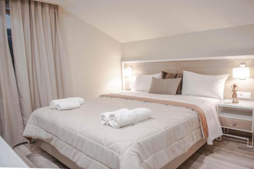 a bedroom with a large white bed with towels on it at Hotel Vizantio in Paralia Katerinis