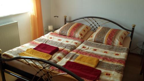 uma cama com cobertores coloridos e almofadas em Ferienwohnung Baur em Tussenhausen
