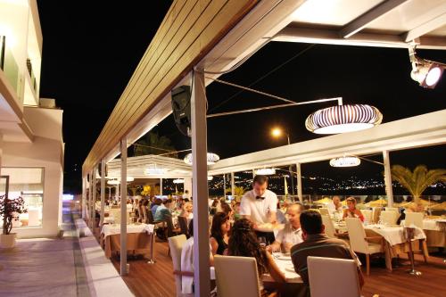a group of people sitting at a restaurant at night at Elite City Resort in Kalamata