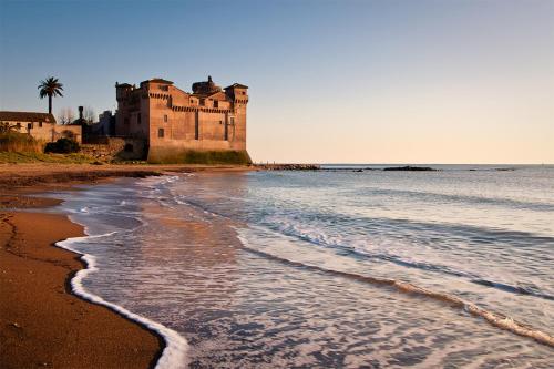 a castle on the beach with the sand and water at Gl106 in Santa Severa