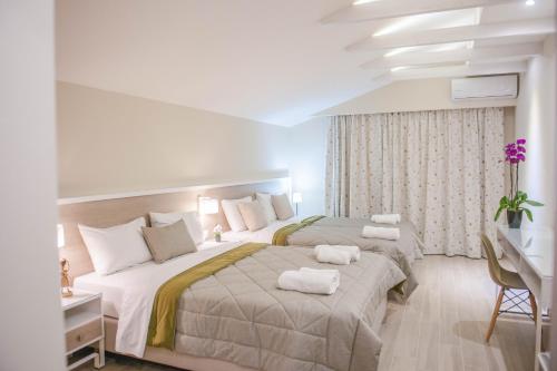 a bedroom with two beds with towels on them at Hotel Vizantio in Paralia Katerinis