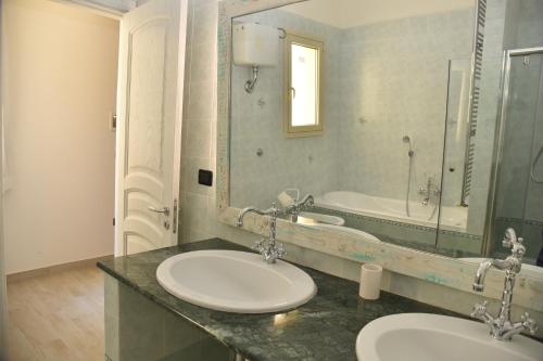 a bathroom with two sinks and a large mirror at Ai Raggi di Sole in Lecce