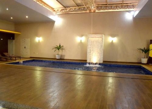 a dance floor with a pool in a room at Lirius Hotel in Primavera do Leste