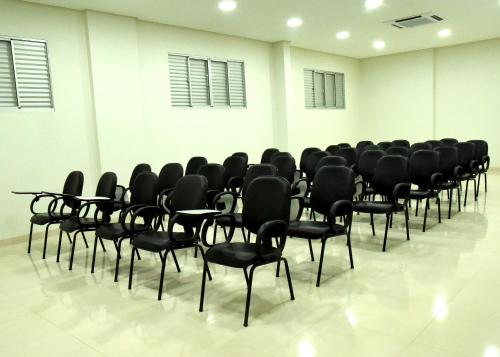a room filled with black chairs in a room at Lirius Hotel in Primavera do Leste