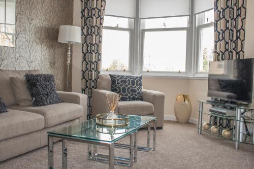 a living room with a couch and a coffee table at Lexington Apartments in Rothesay