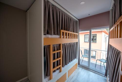 a room with bunk beds and a large window at Sakura Hostel Fethiye in Fethiye