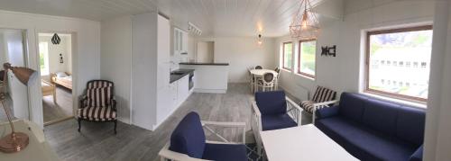 a living room and kitchen with a couch and chairs at Lofoten Bed & Breakfast Reine - Rooms & Apartments in Reine