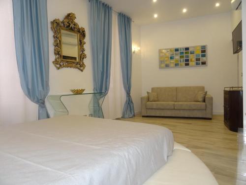 サンタ・マルゲリータ・リグレにあるSuites Margotのベッドルーム(ベッド1台、ソファ、鏡付)