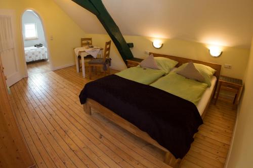 a bedroom with a large bed and a table at Dooscht Gästehaus Reichshof in Kröv