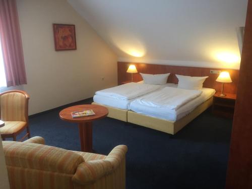 a hotel room with a bed and a table at WH Monteurhotel Papenburg Nord in Papenburg