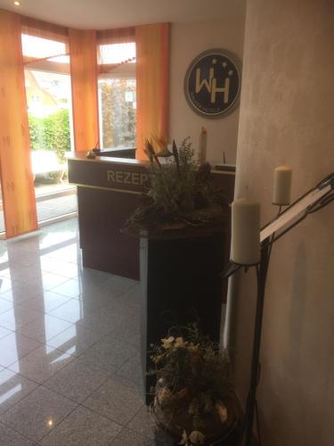 un vestíbulo con recepción con plantas. en WH Monteurhotel Papenburg Nord, en Papenburg