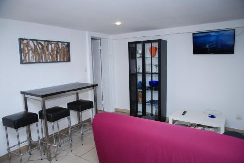 un salon avec un canapé rose et une table dans l'établissement Le Charme, à Wimereux