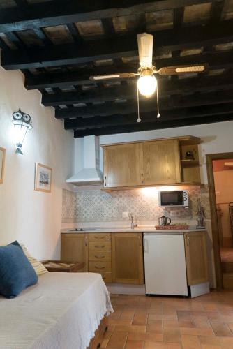 a kitchen with a bed and a sink and a microwave at El Cobijo de Vejer in Vejer de la Frontera