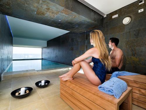 a man and a woman sitting in a bath tub at White Bay in Fontane Bianche