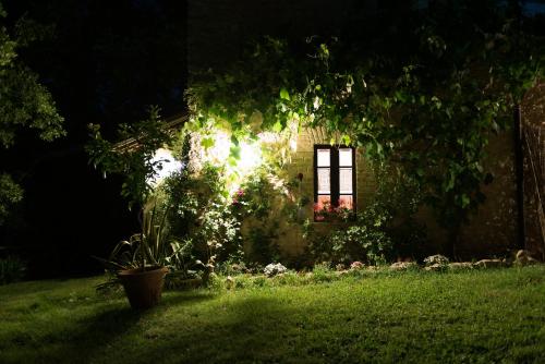 a house with a window in a yard at night at Agriturismo Santa Giusta in Poggio San Lorenzo