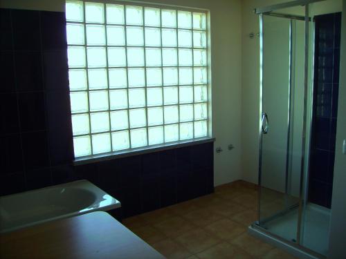 a bathroom with a glass shower and a sink at Villa Ortiga in Mação