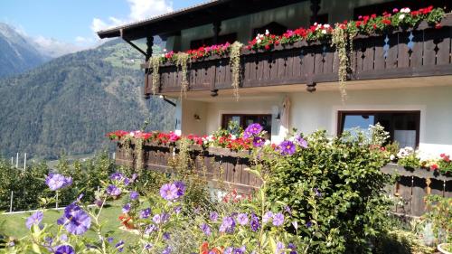 a house with flowers on the side of it at Zimmervermietung Gröberhof in Schenna