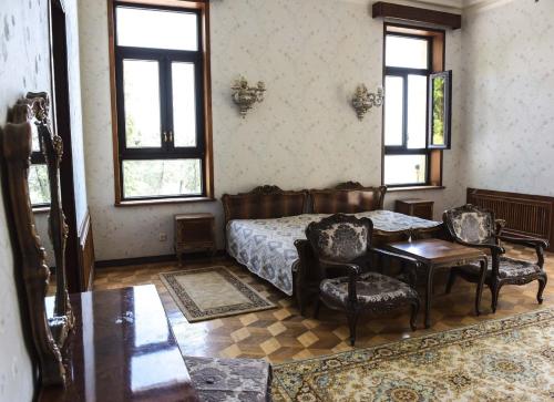 a bedroom with a bed and a table and chairs at Резиденция Президента в Мюссере in Miusera