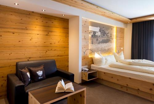 a bedroom with a bed and a chair at Romantica Schlössl in Fiss