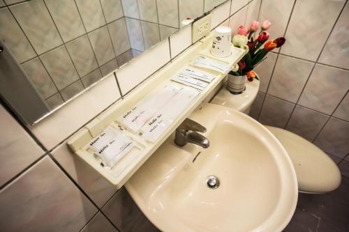 een badkamer met een wastafel en een toilet met bloemen bij 戀戀豐田-鳥鳴民宿 in Fengshan