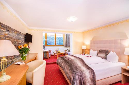 een hotelkamer met een bed en een bureau bij Hotel Alpenkönigin in See
