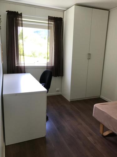 a room with a white desk and a window at Hybeltunet in Meråker
