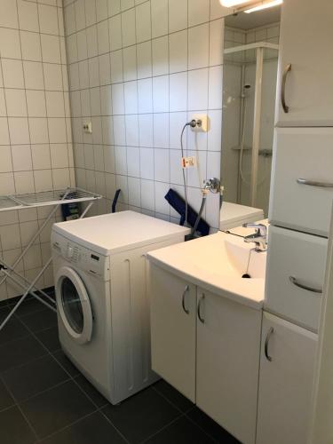 ein Badezimmer mit einer Waschmaschine und einem Waschbecken in der Unterkunft Hybeltunet in Meråker