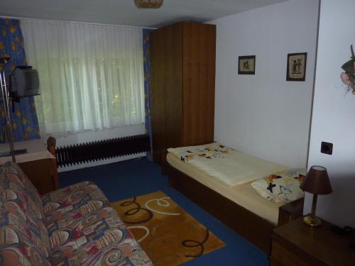 a small room with two beds and a couch at Hotel Heidehaus in Mönchengladbach