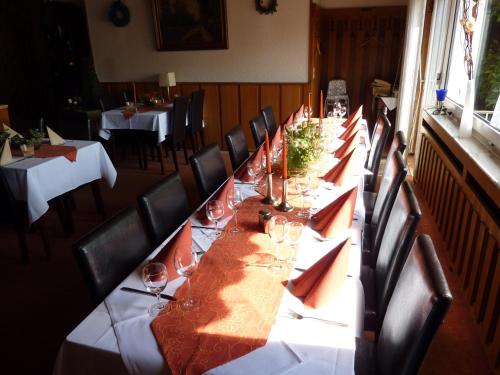 a long long table in a room with chairs and tables at Hotel Heidehaus in Mönchengladbach