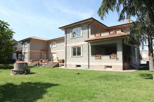 una casa grande con un patio de hierba delante de ella en La Casa di Sofia - Casa Vacanza Monterosi, en Monterosi